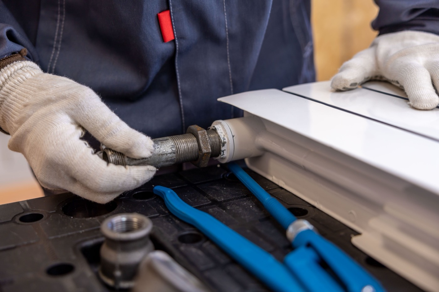 Plumber connecting a pipe fitting to a heating unit